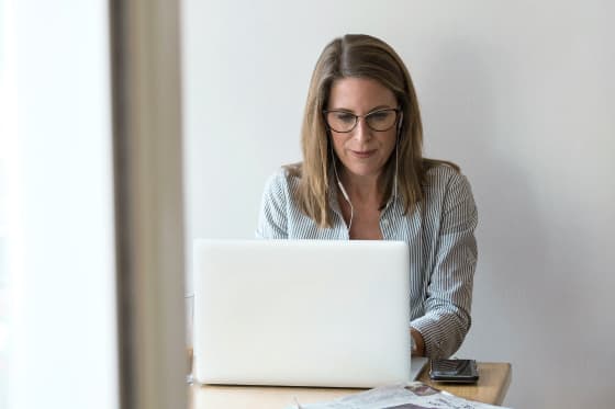 Eine Person schaut konzentriert in den Laptop und bearbeitet eine Kundenanfrage.